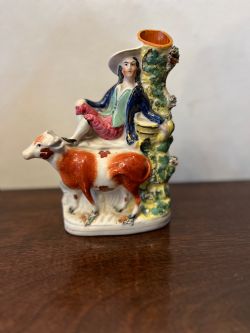 C19TH STAFFORDSHIRE FIGURE OF A HERDSMAN SITTING ABOVE A COW