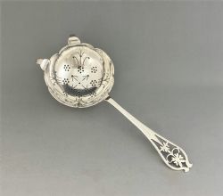 AN ATTRACTIVE SILVER TEA STRAINER