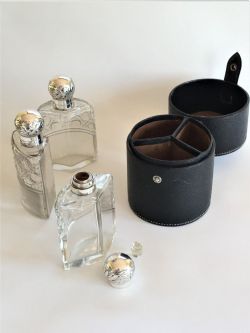 AN UNUSUAL CASED EDWARDIAN SILVER TRAVELLING COLOGNE BOTTLE TRIO