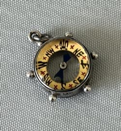 AN UNUSUAL NOVELTY 'SHIPS WHEEL' MINIATURE SILVER FOB COMPASS