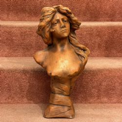 AN ART NOUVEAU TERRACOTTA BUST OF A SEMICLAD YOUNG LADY