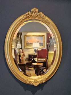 MID VICTORIAN OVAL TIMBER GILT MIRROR